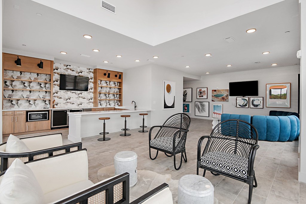 a lounge area with chairs and a bar and a television