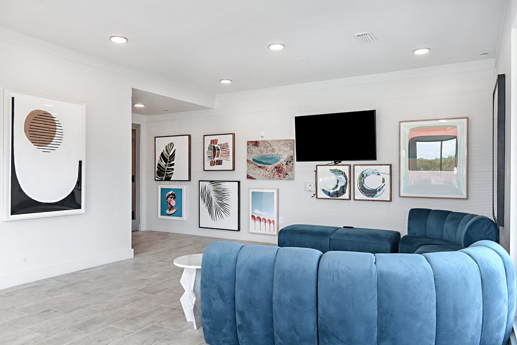 a living room with a blue couch and pictures on the wall