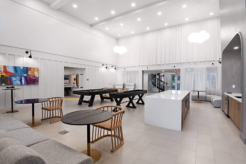a living room with tables and chairs and a kitchen