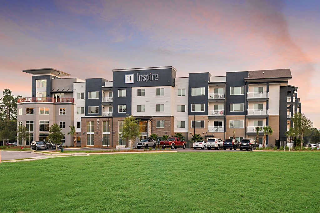 an image of an apartment building with a green lawn