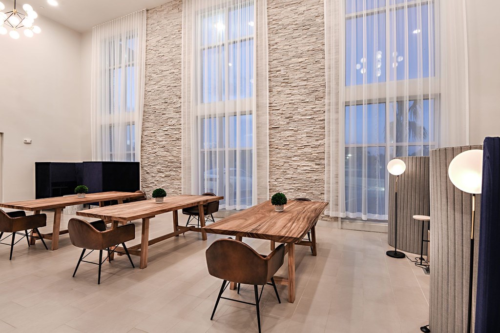 a conference room with tables and chairs and large windows