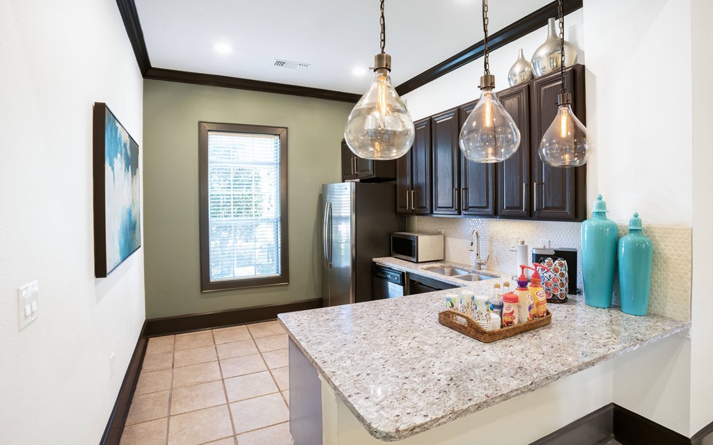 a kitchen with a large island with granite countertops