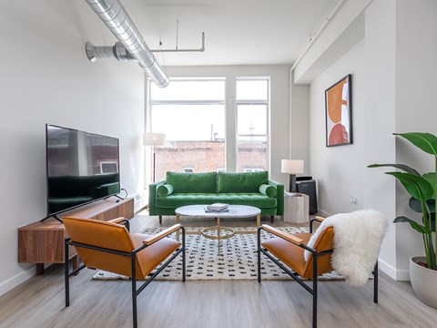 A living room with a green couch and a television.