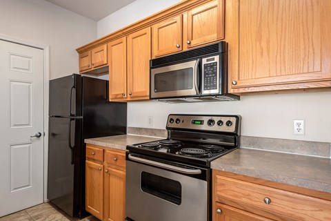 A kitchen with wooden cabinets and black appliances.