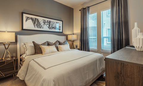 A bedroom with a large bed and a painting above it.