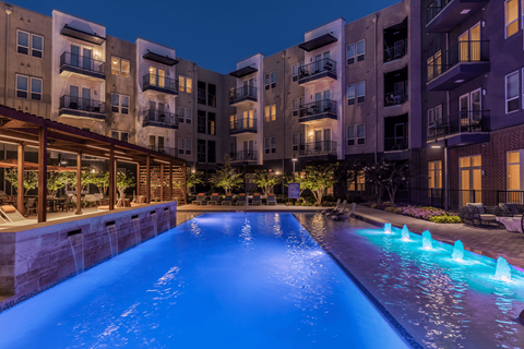 A swimming pool with a fountain in the middle of it.