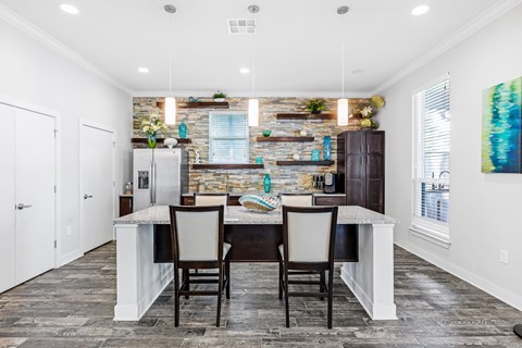 a kitchen with a table and chairs in front of a brick wall