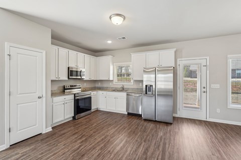 A kitchen with white cabinets and stainless steel appliances.