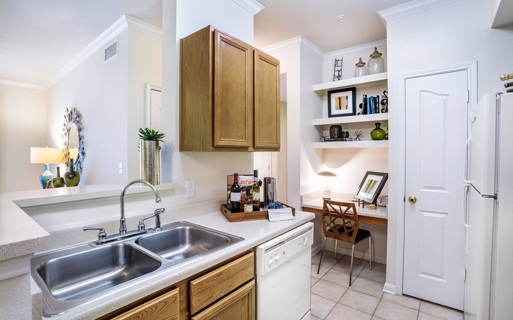 a kitchen with a sink and a desk with a chair