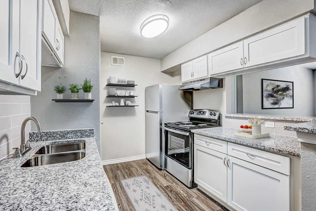 a kitchen with white cabinets and stainless steel appliances