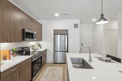 A modern kitchen with a stainless steel refrigerator and a white countertop.