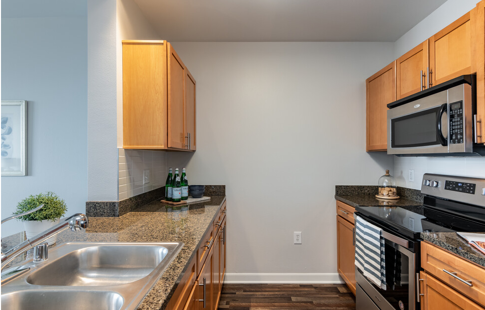a kitchen with granite countertops and wooden cabinets