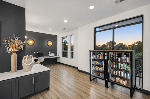 A kitchen with a refrigerator filled with drinks and a view of the outdoors.