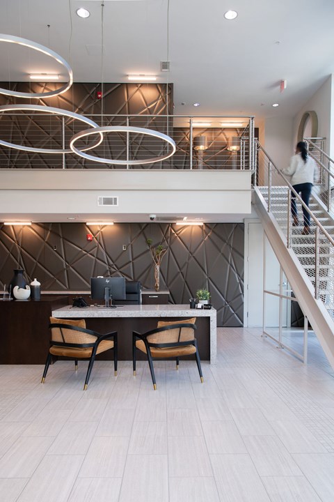 A woman is walking up a staircase in a modern home.