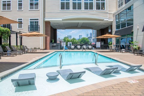 A pool with a red and white sign on the ground.