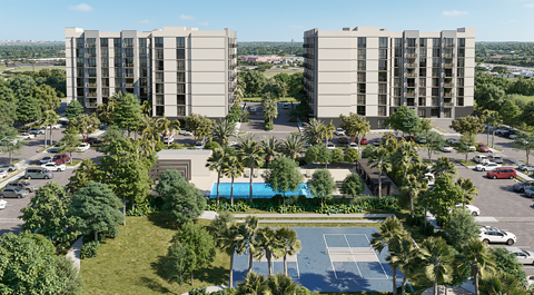 A tennis court is located between two identical buildings.