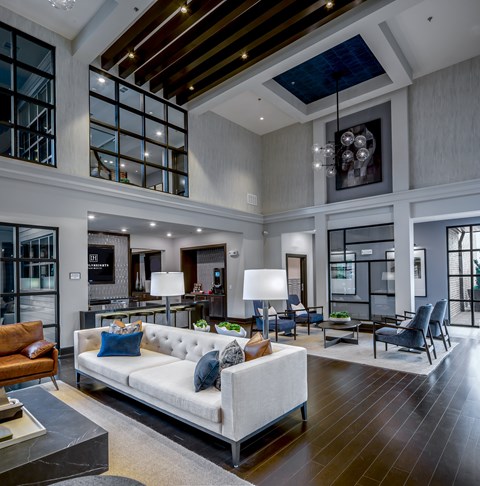 A modern living room with a white sofa and a wooden floor.