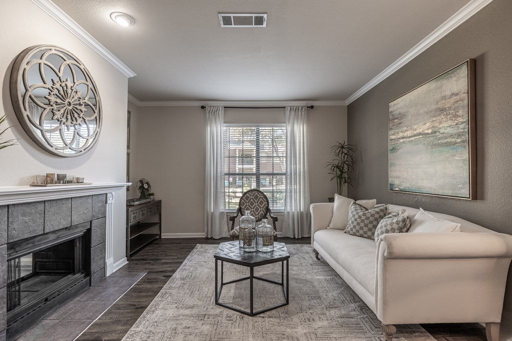 A living room with a fireplace, a couch, and a painting on the wall.