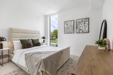 A bedroom with a large bed and a wooden table.