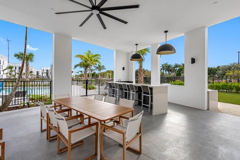 A dining room with a table and chairs and a ceiling fan.