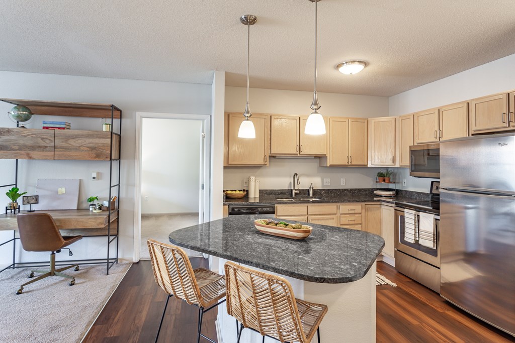 a kitchen with wooden cabinets and a granite countertop at Lake Susan Apartments in Chanhassen, MN