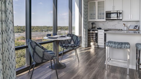 A kitchen with a table and chairs by a window.