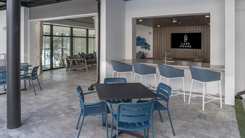 a communal area with a table and chairs and a bar