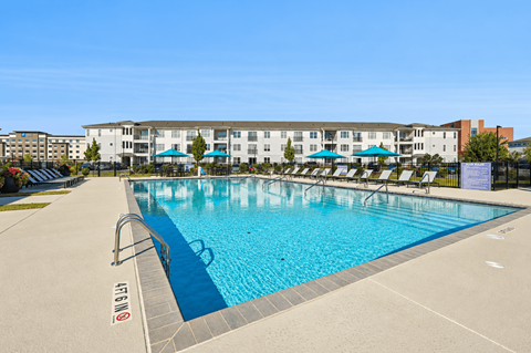 A large swimming pool in front of a multi-story building.