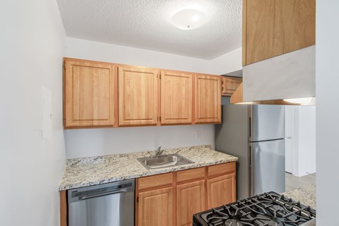 A kitchen with wooden cabinets and a granite countertop.