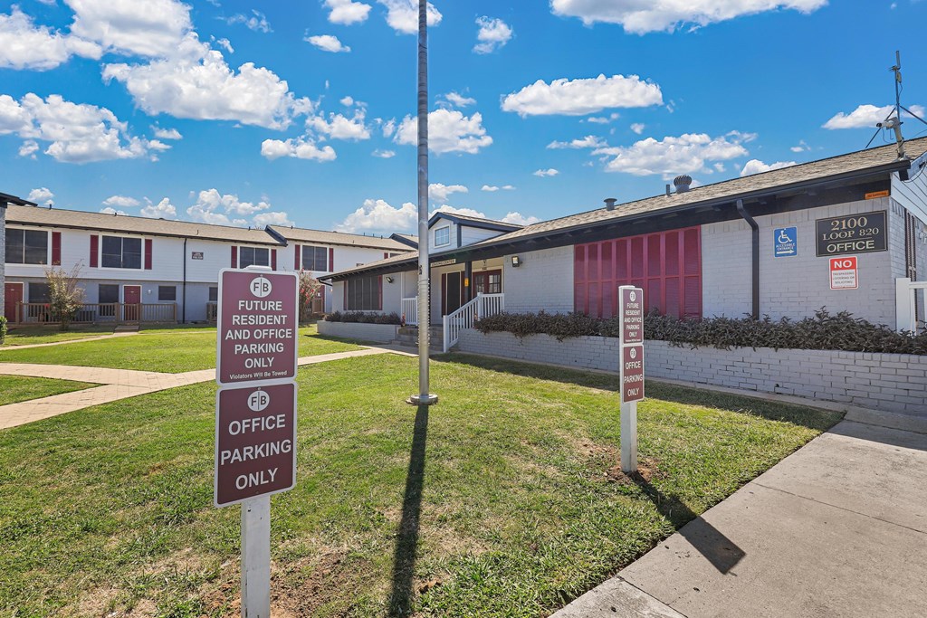 a building with two parking signs in front of it