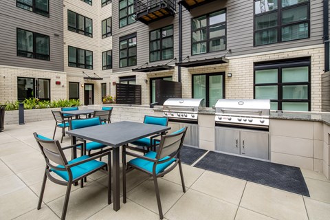 A patio with a table and chairs is surrounded by apartment buildings.