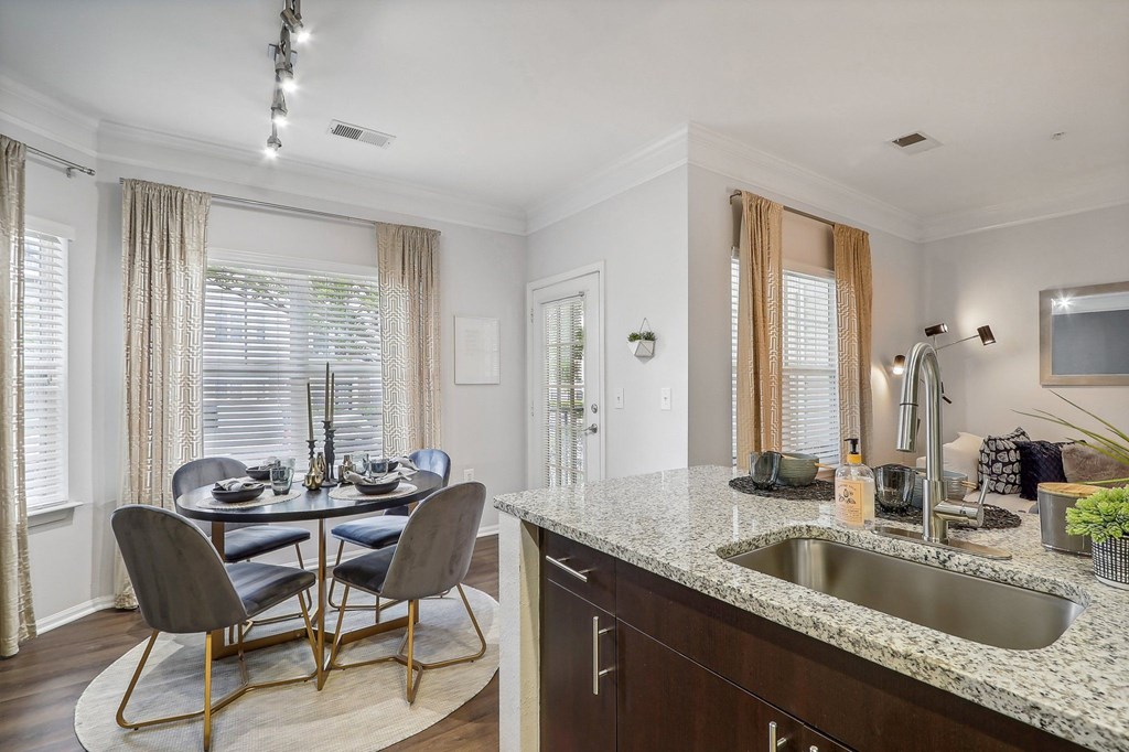 a kitchen with a sink and a table with chairs