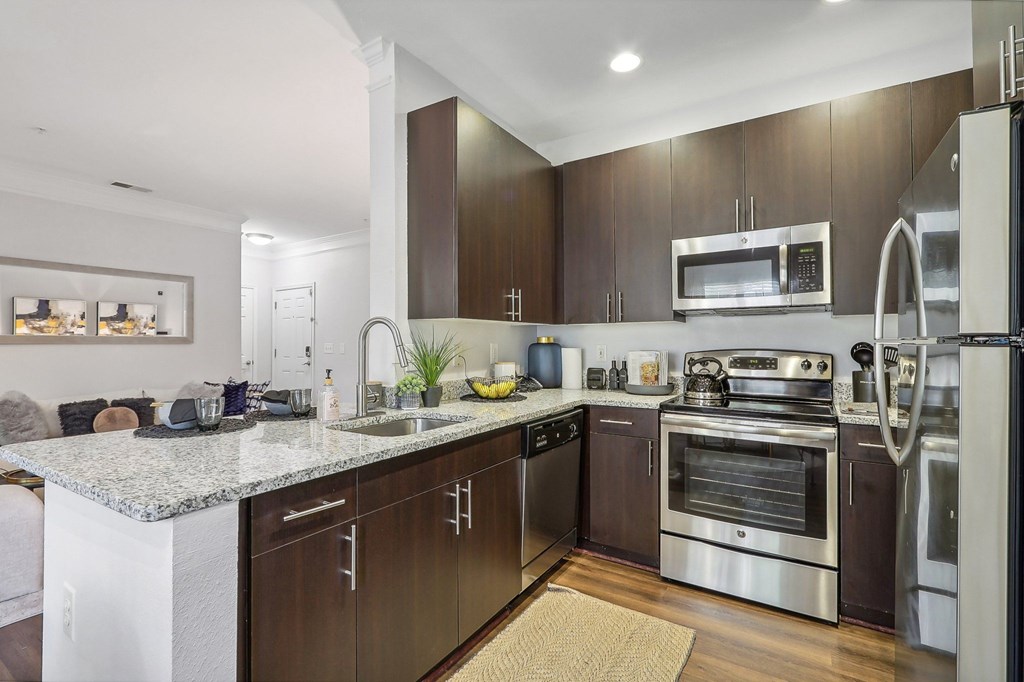 a modern kitchen with stainless steel appliances and marble counter tops