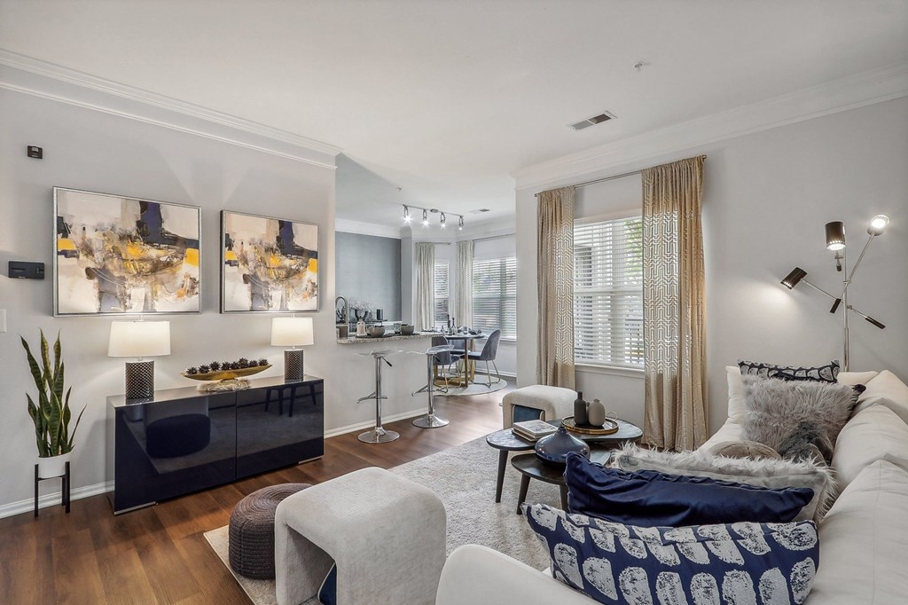 a living room with a couch and chairs and a dining room table