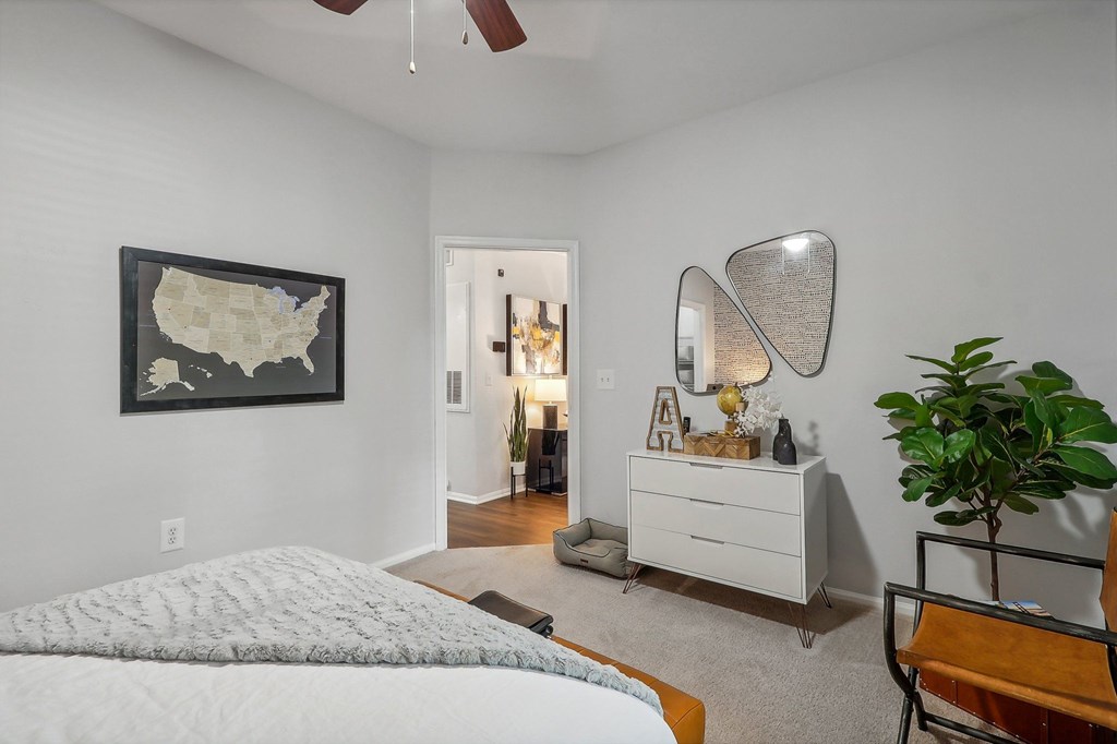 a bedroom with a bed and a dresser and a map on the wall
