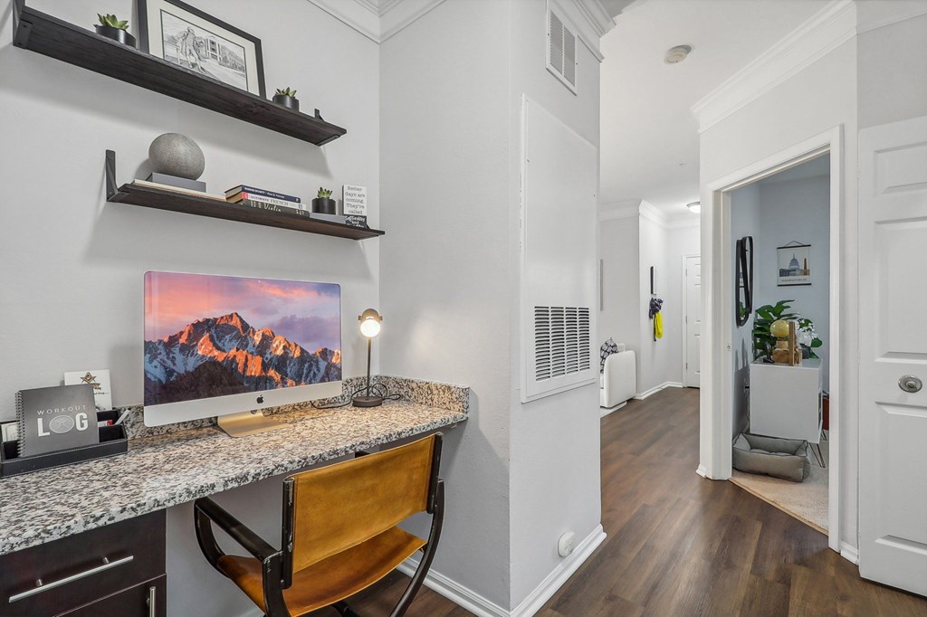 a home office with a desk with a computer on it and a hallway with a