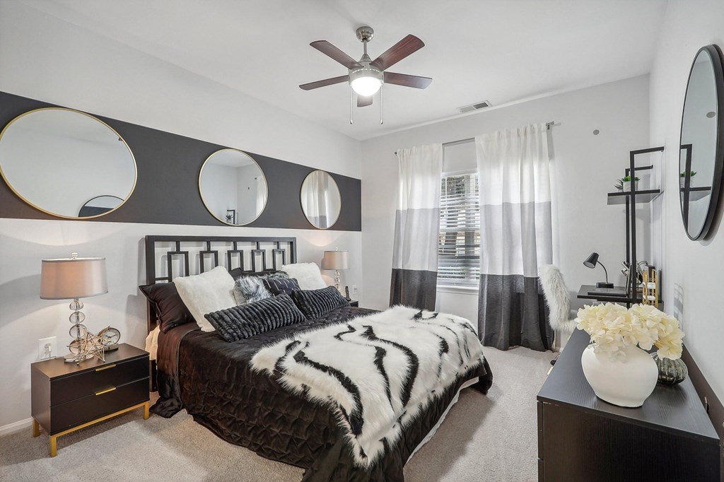 a bedroom with a bed and a ceiling fan