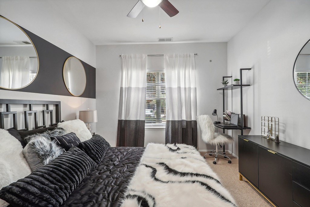 a bedroom with a bed and a desk and a window