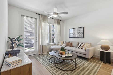 a living room with ceiling fan and a couch and a coffee table
