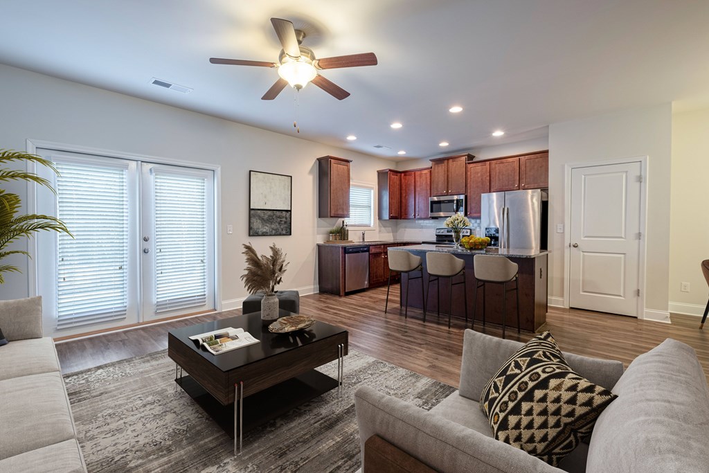 an open living room and kitchen with a ceiling fan