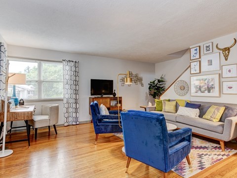A living room with a blue chair and a grey couch.