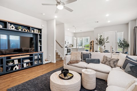 A living room with a white couch and a wooden coffee table.