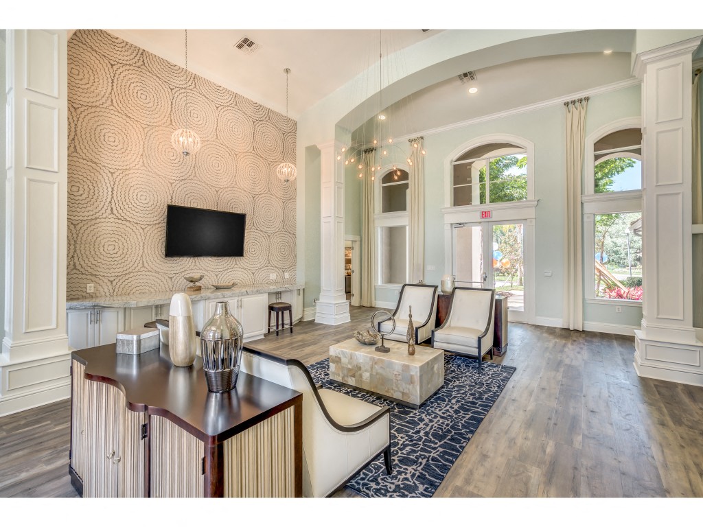 a living room with white furniture and a tv