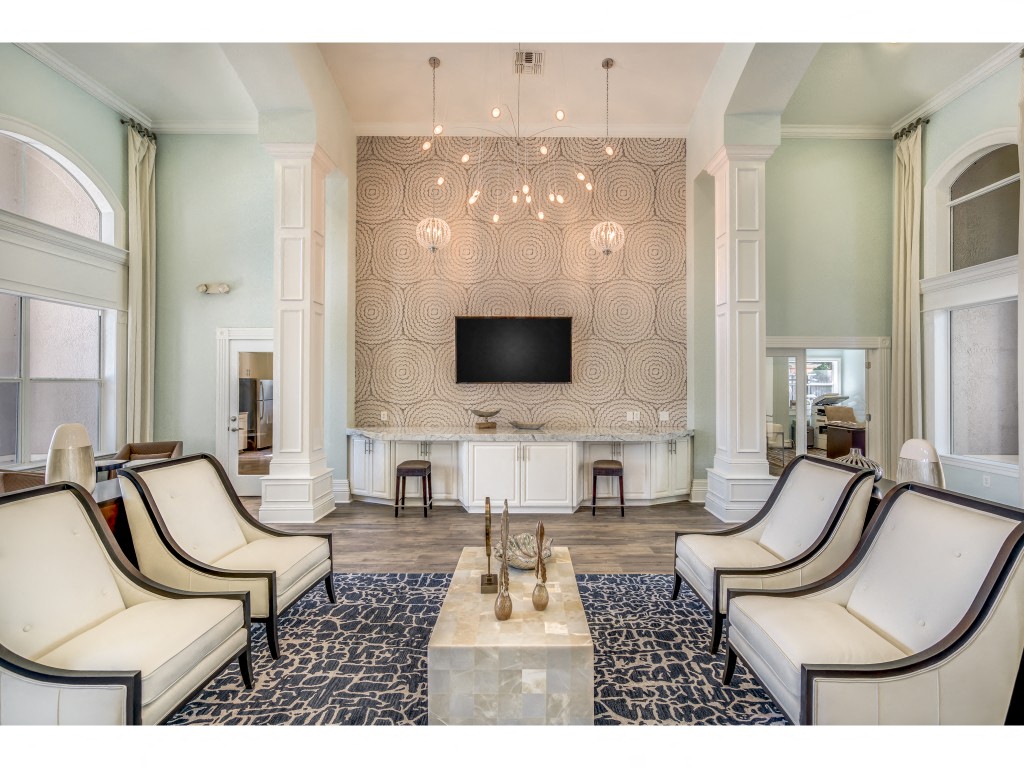 a living room with white chairs and a television