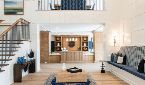 A living room with a staircase on the left and a couch on the right.