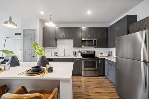 A modern kitchen with a dining table set for two.