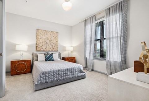 a bedroom with a bed and a large window