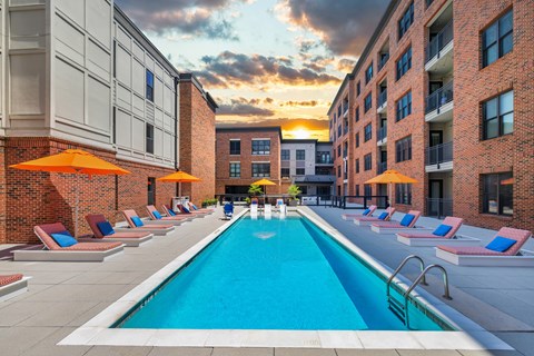 a swimming pool in the middle of a building with orange umbrellas