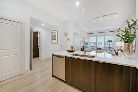 A modern kitchen with wooden cabinets and a white countertop.