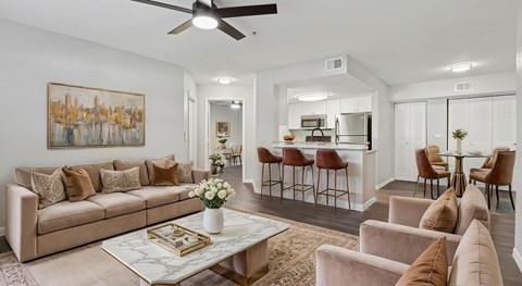 A living room with a beige couch, a coffee table, and a painting on the wall.